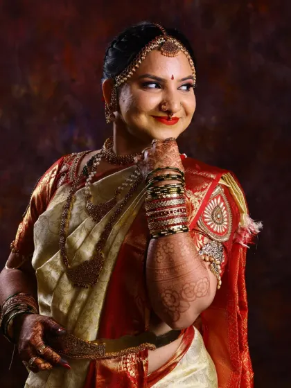 A classic portrait of a bride in her traditional attire. Her mehndi is an essential part of her look, with the dark stain on her hands and arms adding to her bridal glow.