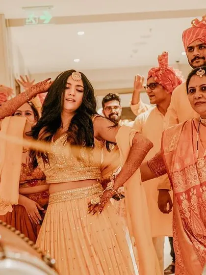 A wide shot of the bride dancing with her family and friends, a perfect capture of the Sangeet celebration.