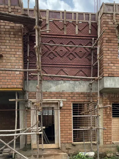 This feature wall, inspired by the 'Kasuti' embroidery of Karnataka, is seen here during construction. The intricate brick pattern is a key feature of the home.