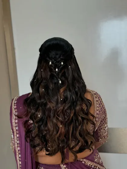 A simple yet elegant hairstyle for the sister of the bride, featuring soft braids and pearl accessories.