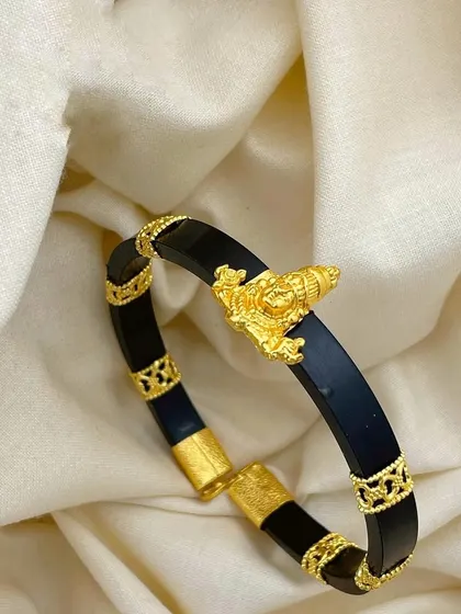 This 92.5 silver gold-plated men's kada features a Shankha (conch) motif. The black band contrasts beautifully with the intricate gold-plated details, making it a unique spiritual accessory.
