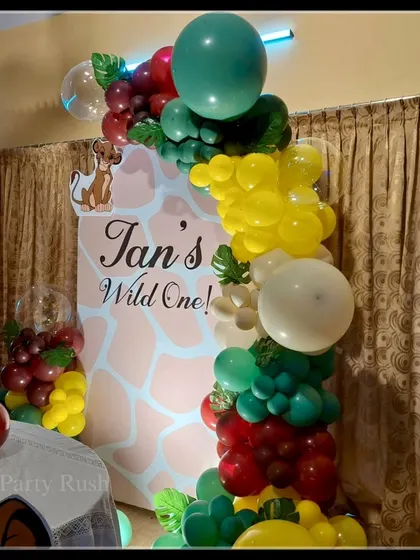A close-up of the balloon details from Ian's Lion King-themed first birthday party, showing the rich, earthy colors and jungle leaf accents.