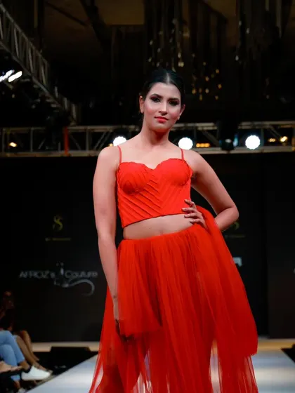 The vibrant red gown in full view, a testament to the bold and beautiful designs featured in the show.