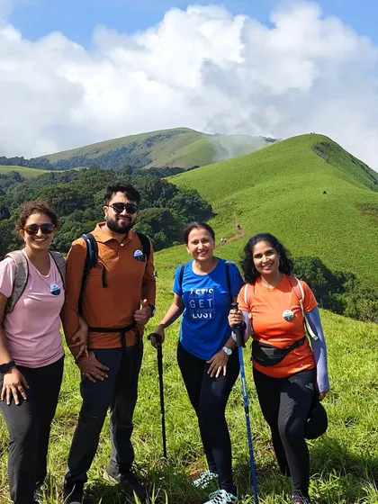 Our trekkers, equipped with walking sticks, pose against the stunning backdrop of the green hills of Bandaje.