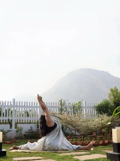 A beautiful Hanumanasana (split) with a heart-opening backbend, practiced outdoors with a mountain view.