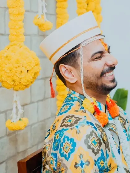 The groom's happy and relaxed expression during his Haldi ceremony, enjoying the traditions with his family.