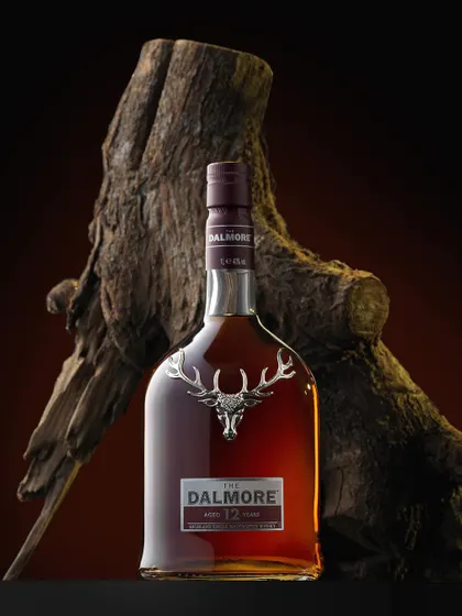 This moody shot of The Dalmore 12 was inspired by the weather on the day of the shoot. The gnarled wood provides a rugged, natural backdrop that contrasts beautifully with the bottle's elegant design and the iconic silver stag.