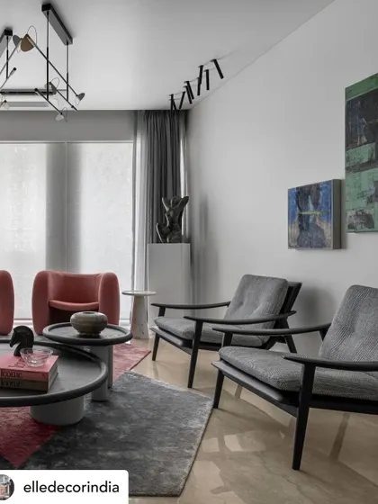 This angle highlights the gallery-like feel of the space. Multiple artworks are displayed against a clean white wall, while a statue stands on a pedestal, reinforcing the idea of the home as a curated collection of beautiful objects.
