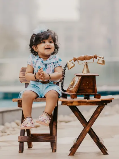 A sweet poolside portrait of a baby girl celebrating her first birthday. The vintage telephone prop adds a touch of whimsy.