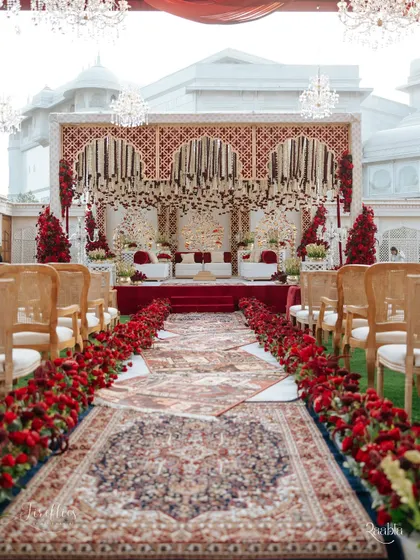 The aisle for Naomi and Rakshit's 'Laal Ishq' wedding, leading to a magnificent mandap. We used a series of ornate Persian rugs for the walkway, bordered by a dense arrangement of red roses, setting a regal tone for the ceremony.