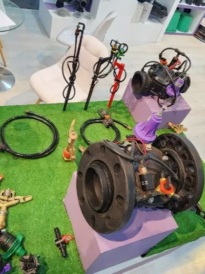 A close-up of the various micro-sprinklers, valves, and fittings we offer, displayed on a turf mat at the Sahara Expo.