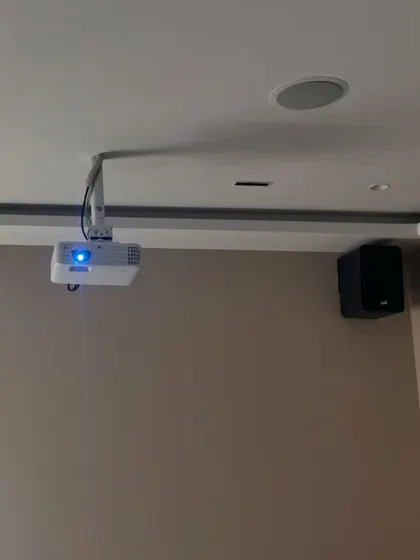 This shot shows the placement of the projector, a wall mounted surround speaker, and an in ceiling Atmos speaker. This combination creates a three dimensional sound field for a truly immersive Dolby Atmos experience.