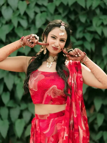 The bride playfully shows off her mehndi-stained fingers, a fun and quirky portrait.