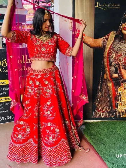 Try on your dream red bridal lehenga at my store. This piece features beautiful floral embroidery and is perfect for the main wedding ceremony.