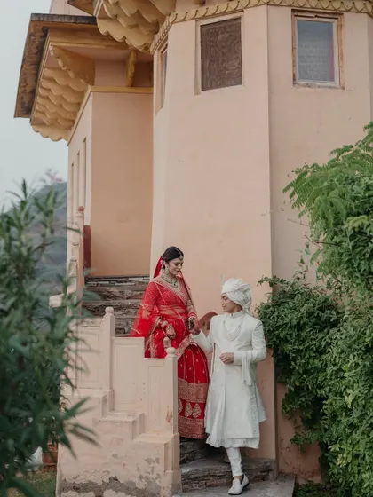 A romantic shot of the couple on the steps of Neemrana Palace, capturing a quiet moment of connection with the magnificent fort in the background.