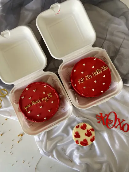 A pair of hot red bento cakes, one cheekily saying "RIP 20s Hello 30s" and the other "You Power my BI" for a techie partner. These are perfect for milestone birthdays or celebrating a relationship.