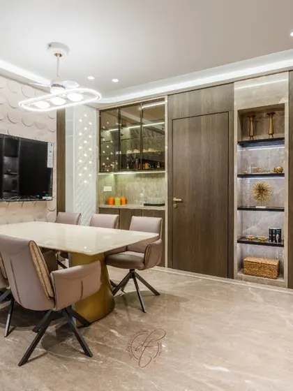 This perspective captures the full expanse of the dining and storage area. The design showcases our ability to integrate functional elements like storage and a TV unit into a cohesive and glamorous aesthetic.