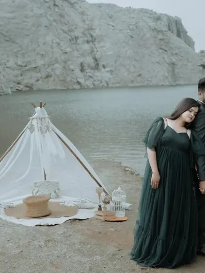 A wide, scenic view of a couple's styled pre-wedding shoot by a quarry lake, showing the beautiful setup and the stunning natural location.