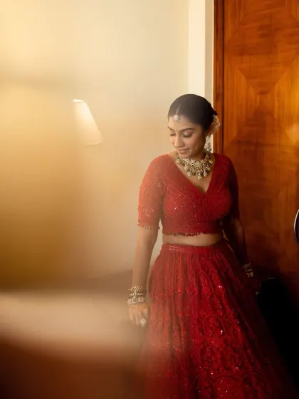 A candid moment of the bride, Aayushi, in her room before the ceremony. The warm, soft lighting creates an intimate and gentle mood.