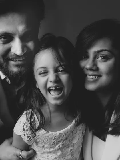 A candid black and white shot bursting with laughter. This is the kind of authentic, joyful moment we strive to capture for every family.