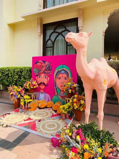 A quirky Rajasthani-themed photo booth for a Mehendi, complete with a painted camel prop.