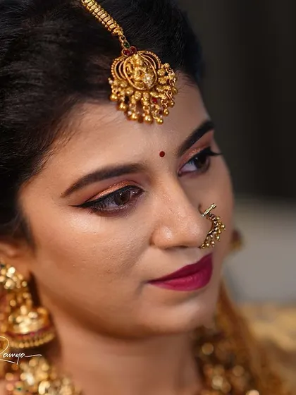 Meghana's complete traditional look, with her hair being styled and jewelry in place.
