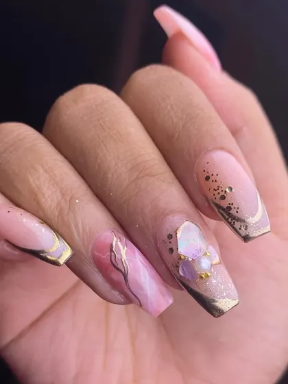 Festive and refined. This design on square-shaped extensions combines a pink marble accent, gold foil details, and a delicate 3D flower, proving that festive nails can also be incredibly chic.