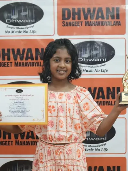A happy student with her certificate and trophy, a symbol of her dedication.