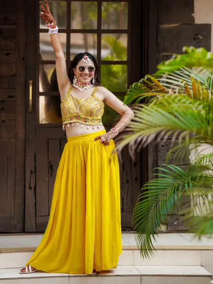 The bride strikes a pose, full of energy and excitement for her Haldi ceremony.