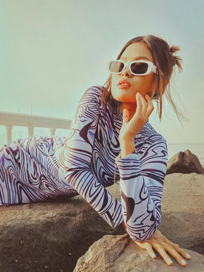 A striking pose on the rocks, using the golden hour light to create a warm, glamorous feel for this solo fashion portrait.