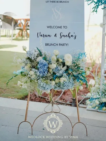 The details of our tropical pool party decor. The tables featured custom blue and white linens, with centerpieces of white-painted pineapples and blue-tinted water bottles holding fresh flowers.