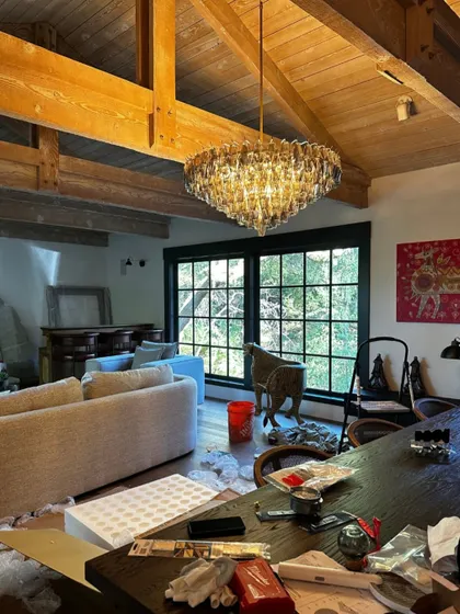A work-in-progress shot of the Saratoga living room, with the chandelier just installed. Even amidst the unpacked boxes, you can feel the warmth and character of the space coming to life.