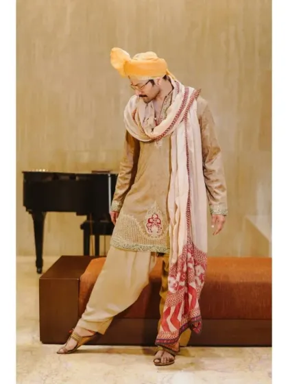 A stylish pose from the groom, showing off the flow and design of his wedding attire. This shot adds a touch of fashion and personality to his wedding album.