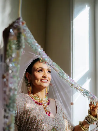 The sun catching Tithi's smile through her veil. Her glowing skin looks absolutely luminous.