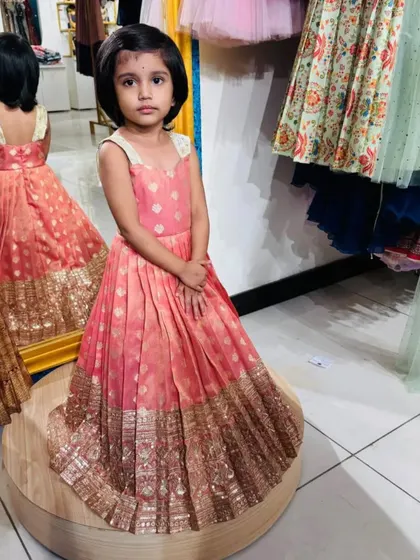 Posing like a pro. This custom-designed frock is perfect for little fashionistas who love to stand out. The sleeveless design and pleated skirt ensure she's comfortable while looking her absolute best.