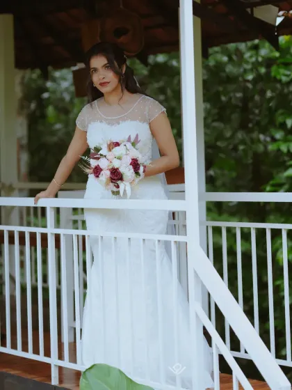 A full-length shot of a Christian bride on a balcony, showcasing her dress and the natural surroundings.
