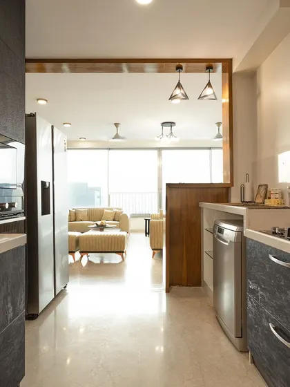 A view from the galley kitchen into the open living area, showcasing a design that is both connected and distinct. The dark cabinets provide a sleek, modern feel.