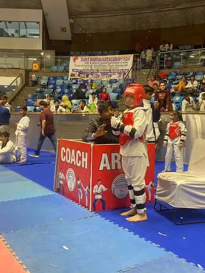 A young fighter ready by the coach's box at the national championship.