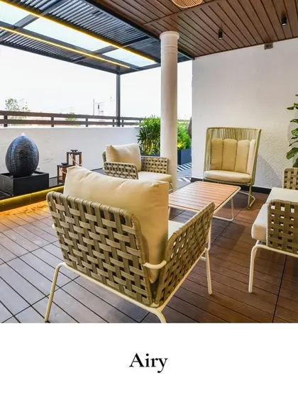 A cozy corner to sip, relax, and soak in the view. This airy balcony features comfortable woven armchairs and a sleek design, perfect for an urban retreat.