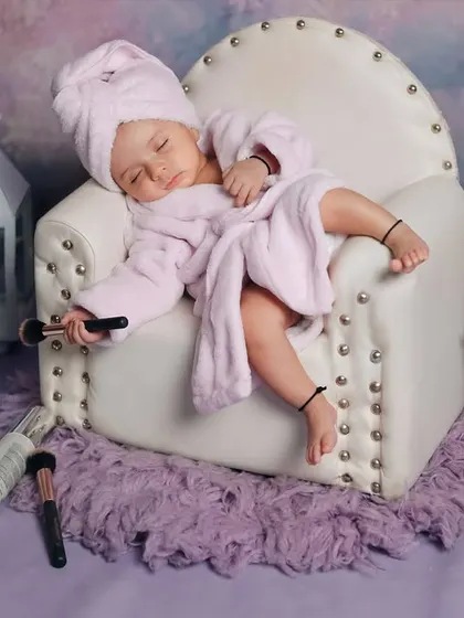 A wider shot of the hilarious 'Mini Spa Day' setup. The baby is completely relaxed, surrounded by all the essentials for a day of pampering.