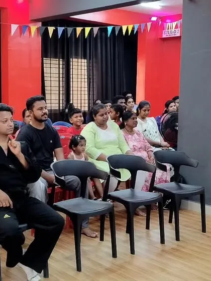 A view of the audience from the side. Parents and family members watching the performances with pride.