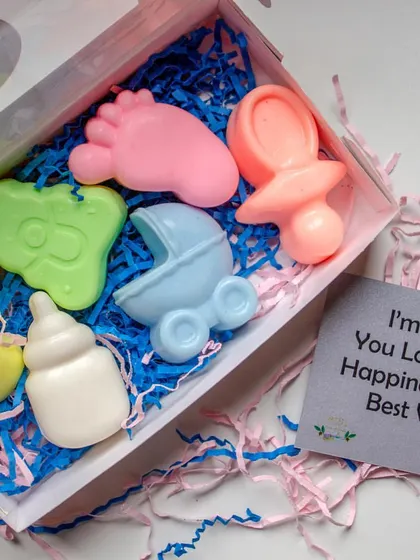 These baby shower themed soap boxes make for wonderful return favors. Each box contains a set of handcrafted soaps shaped like a baby foot, a rattle, and a bottle, made with gentle Shea Butter and Coconut Oil.
