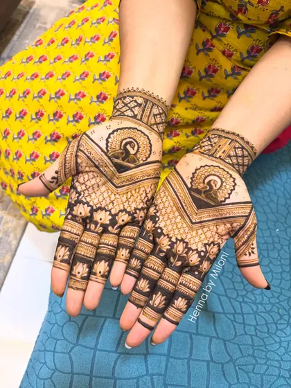 A classic Indian mehendi design featuring a central peacock mandala. The pattern is symmetrical and uses negative space to make the motifs pop.