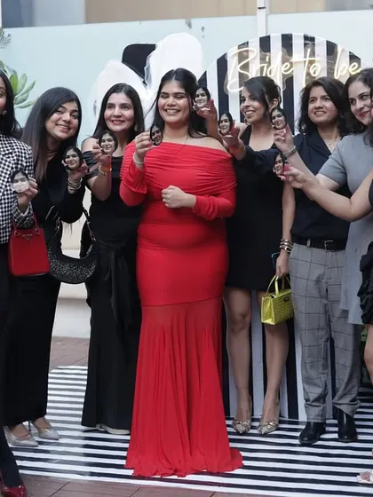 The bride-to-be surrounded by her tribe, all raising a custom shot in her honor.