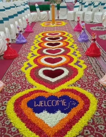 A heart-themed floral rangoli made with colorful petals. This design is perfect for welcoming guests to a wedding or engagement, filling the entrance with love.