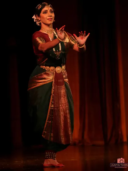 The 'pataka hasta' or hand gesture with a flat palm, used here to signify assurance or blessing. Hand gestures, or mudras, are the vocabulary of Bharatanatyam.