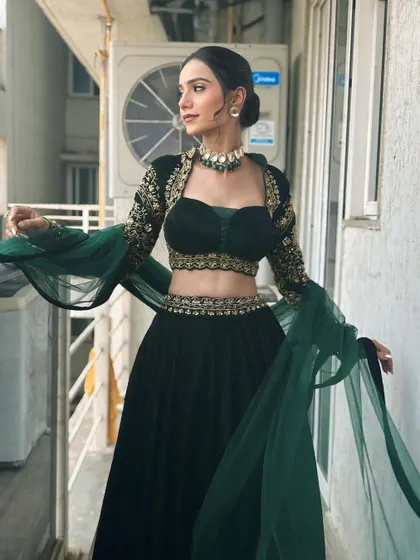 A full-length shot showcasing the dramatic sleeves and flow of the lehenga. The entire look is balanced, with the makeup complementing the outfit perfectly.