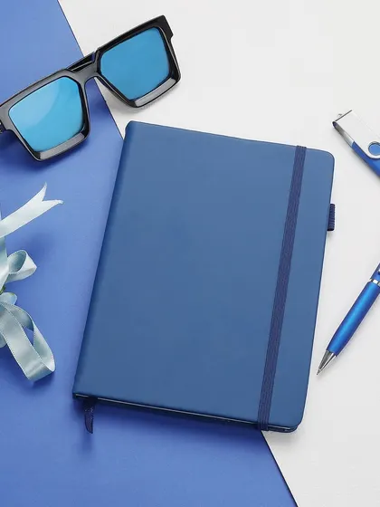 We excel at creating styled flat lay compositions that enhance product appeal. This arrangement of a blue corporate notebook set with complementary accessories shows how we build a visual narrative for your brand, perfect for social media and website banners.
