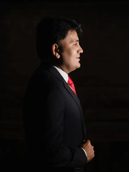 A dramatic solo portrait of the groom-to-be. The use of shadow and light creates a sophisticated and timeless look, perfect for a classic groom portrait.