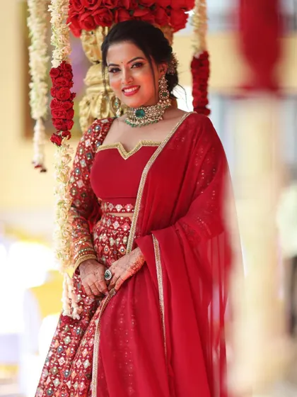 Another beautiful shot of the model in the red bridal lehenga, highlighting the rich color and detailed embroidery.